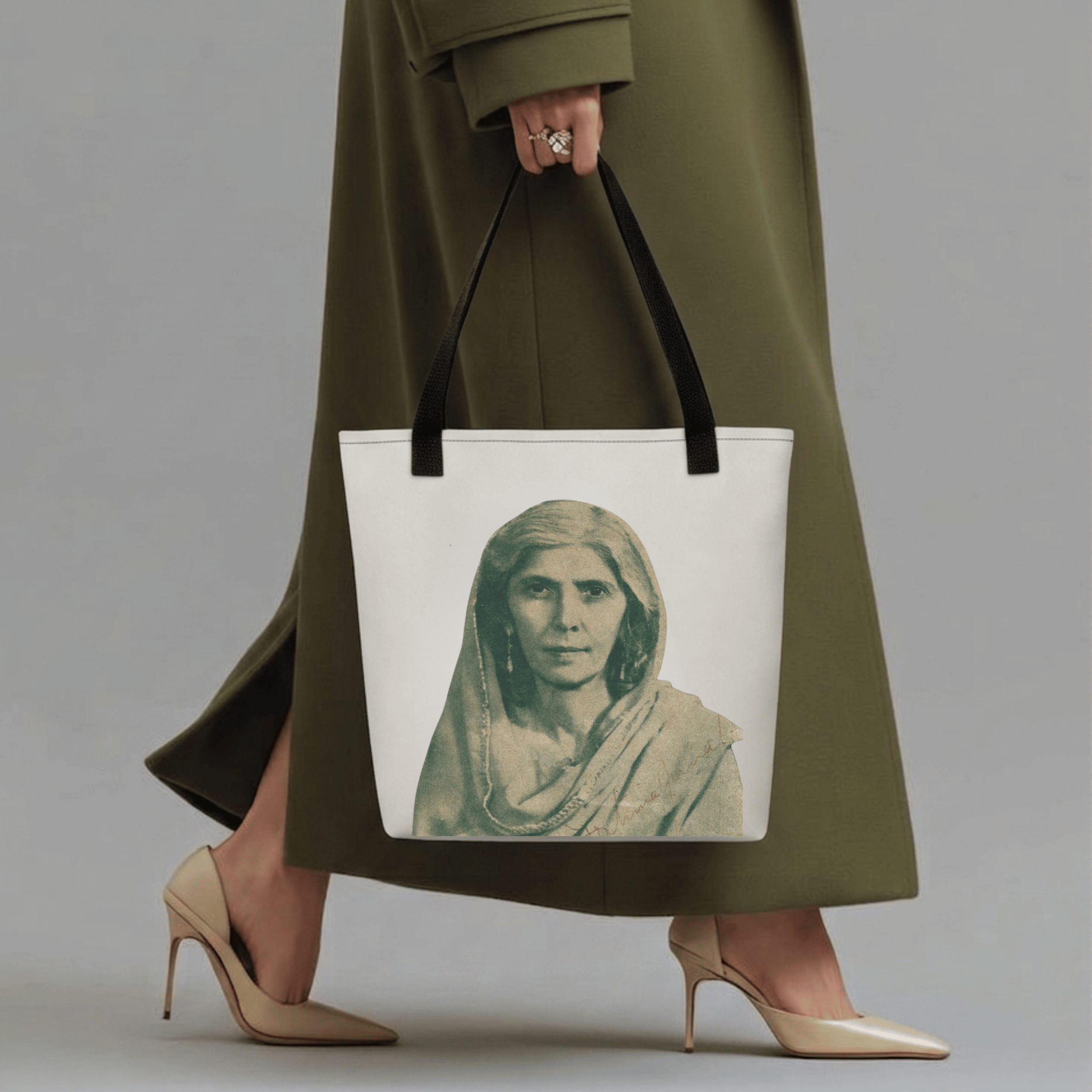 Madar-e-Millat Heritage Tote Bag with monochrome portrait print, held by a woman in an olive coat